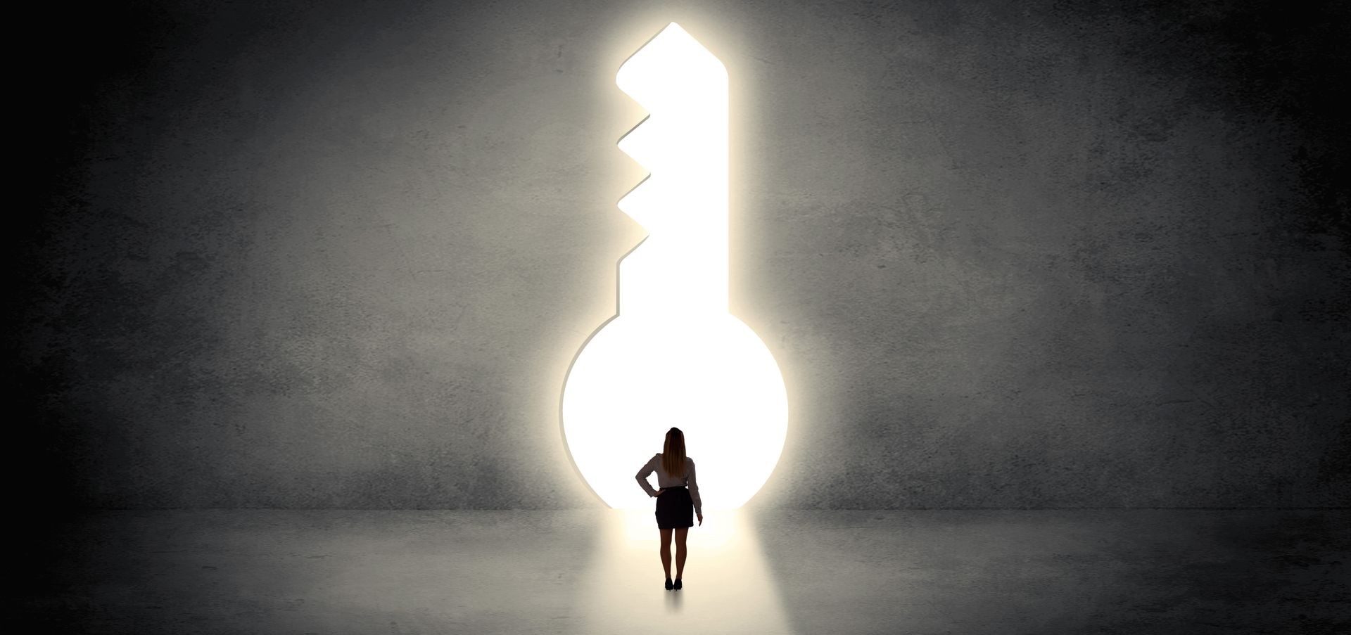 Woman standing alone in front of a big keyhole